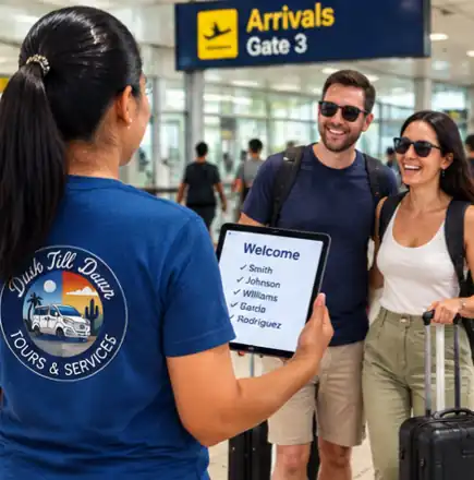 A Dusk till Dawn host welcomes smiling travelers at the airport arrivals hall with a name list on a tablet